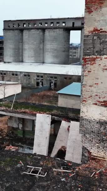 爆撃された建物のレンガの壁と窓の穴 空爆による破壊された建築 ドローンショット バーティカルビデオ — ストック動画