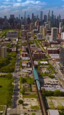 Güneşli bir günde modern Chicago 'nun güzel manzarası. İnsansız hava aracı yeraltı demiryollarına iniyor. Arkaplanda gökdelenler. Dikey video.