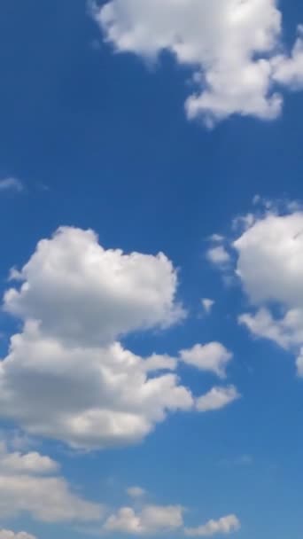 小さな白い綿の雲が青空に現れ消えていく 晴れた日のタイムラプスの低い角度ビュー バーティカルビデオ — ストック動画