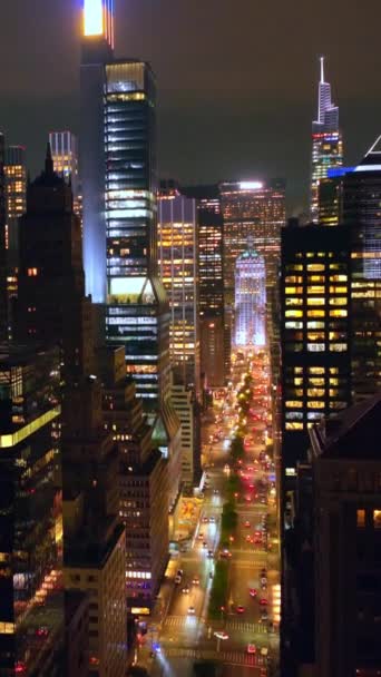 ライトが付いている驚くべき高層ビル ドローンは夜に華やかな建物の上に上昇する 曇った空の背景 バーティカルビデオ — ストック動画