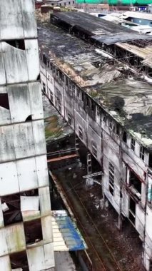Eski bir kimya fabrikasının çürümüş dış cephesi. Havadan bakıldığında, binaların duvarları ve çatıları gri renkteydi. Dikey video.