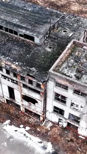 古い放棄された工場の大規模な建物は 非常に長い間使用されませんでした 壁の窓や部分がない空の敷地 空からの眺め バーティカルビデオ — ストック動画
