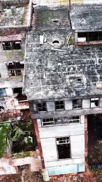 壊れた工場の建物の内側と外側の建物のデブリと建設ゴミ 空中視点から外れた廃プラント バーティカルビデオ — ストック動画