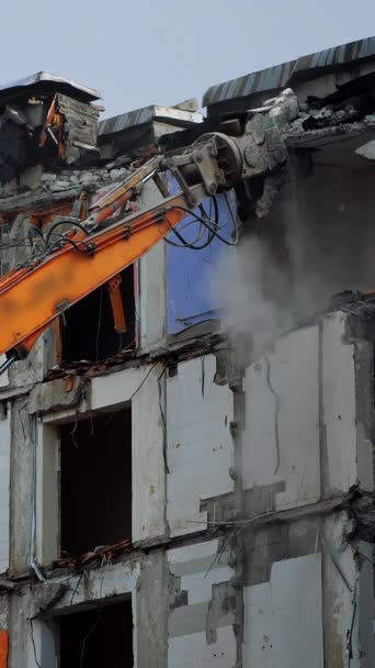 地震で破壊された高層ビル 破壊された建物の屋根を破壊するデモ機械 ロングマシンの爪が破片を引き下ろした バーティカルビデオ — ストック動画