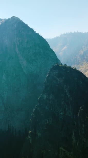 明るい光と霧の中の高い山 アメリカ合衆国カリフォルニア州ヨセミテ国立公園の豪華な美しい岩 バーティカルビデオ — ストック動画