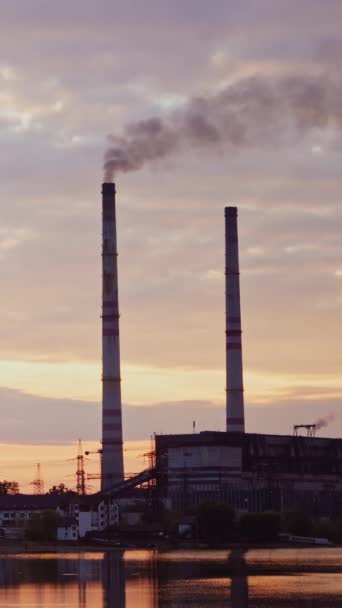 工厂在农村 早上在河边附近的工业区 在夜晚的大自然中 有害的烟雾从制造业中飘进空气中 垂直录像 — 图库视频影像