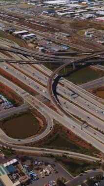 Salt Lake City 'nin sanayi bölgesinde birden fazla yol kesişiyor. Utah otobanlarından geçen yüzlerce araba. En üst perspektif Dikey video.