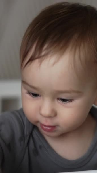ベビーベッドに立っている小さな可愛い赤ん坊は 目を覚ました後 カメラの前で面白い顔をするかわいいトッドラー クローズアップ バーティカルビデオ — ストック動画