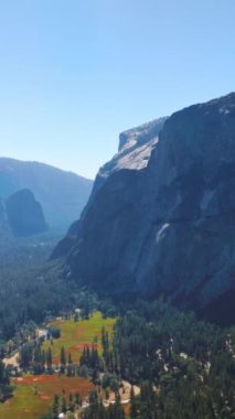 Parlak güneş büyük dağların arasındaki güzel vadiyi aydınlatıyor. Yosemite Ulusal Parkı, Kaliforniya, ABD 'nin göz kamaştırıcı manzarası. Dikey video.