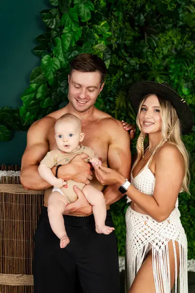 The couple are pictured with their son who was born in March.