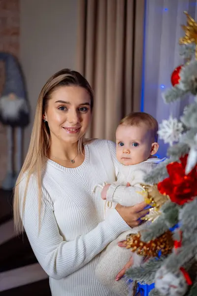 Joven Madre Sostiene Bebé Sus Brazos Sonríe Árbol Navidad Regalos — Foto de Stock