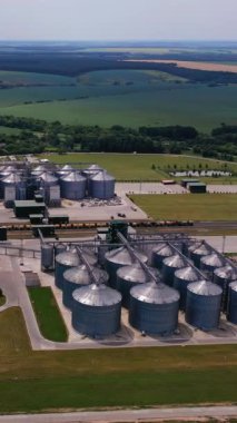 Şehrin dışındaki ekinleri depolama ve işleme için tarım tesisi. Yeşil alanları ve yolları olan iyi organize edilmiş bir tesis. Hava görüntüsü. Dikey video