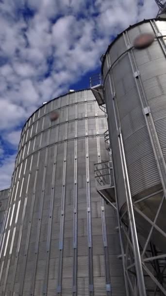 室外现代粮仓 储存谷物的金属电梯 农业综合体 蓝天之下有巨大的铝容器 垂直录像 — 图库视频影像