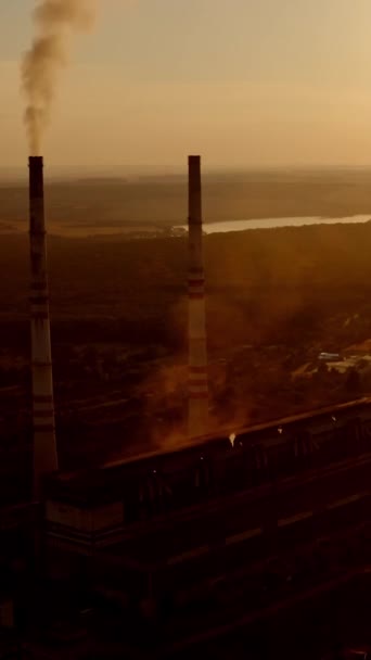 自然界の産業地帯 産業工場からの有害な煙は日没時に空気を汚染する 川の近くにある工場 生態学的な問題 バーティカルビデオ — ストック動画