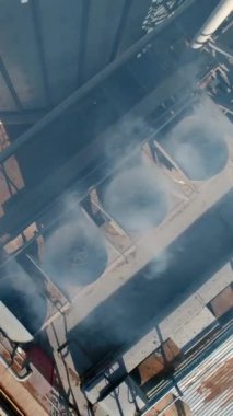 Endüstriyel fabrikadan buhar. Buğday işlemek için modern fabrikada buhar. Tahıl asansörleri. Üretimden çıkan zararlı duman havaya karışır. Üst hava manzarası. Dikey video