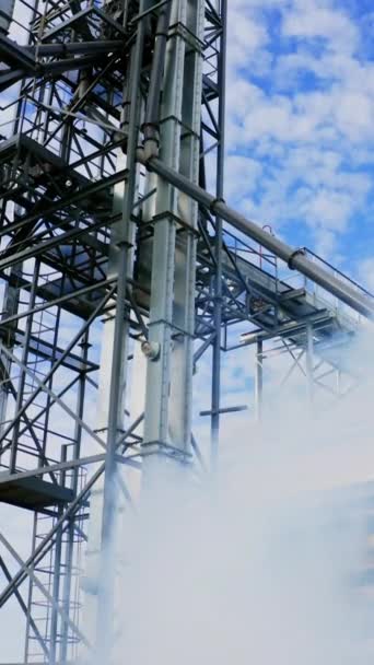 一个大型工厂的厂房建设 蓝天背景下的钢结构 工厂的室外白烟 垂直录像 — 图库视频影像