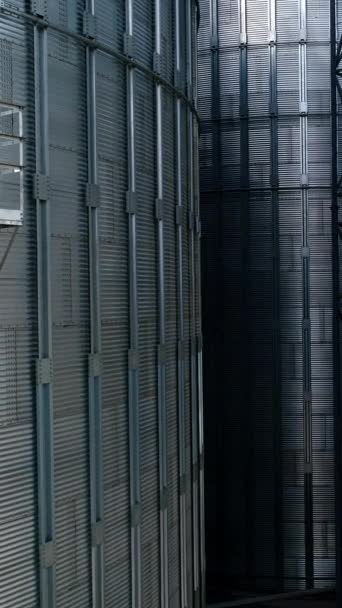 用于储存谷物的大型金属筒仓 现代工业厂房 储存农作物的银容器 大自然背景下的谷物电梯 移动起来 垂直录像 — 图库视频影像
