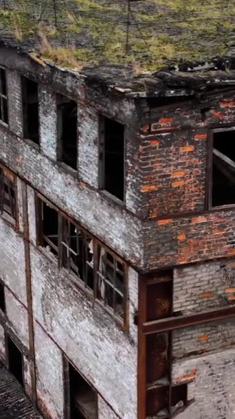 軍事行動の後に建造された 壊れた窓と壁の多くの穴で放棄された建物 屋外で破損した建物 空からの眺め バーティカルビデオ — ストック動画