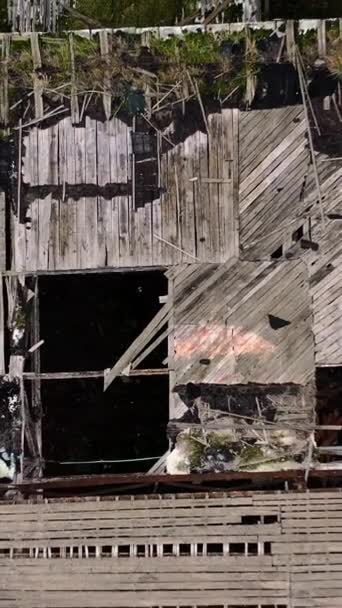 軍事行動の間に建物の屋根を損傷した 屋外に多くの穴をあけて放棄された建物 トップ空中ビュー カメラが上がった バーティカルビデオ — ストック動画