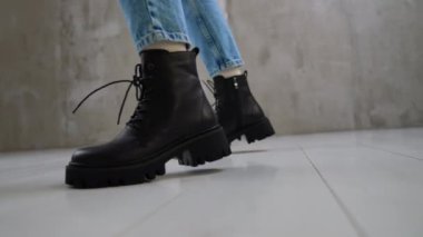 Kot pantolon ve beyaz çorap giyen manken siyah çizme gösterir. Dişiler için uygun soğuk hava ayakkabıları..