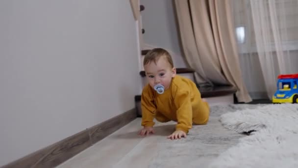 神奇可爱的蹒跚学步的幼儿 嘴里衔着奶嘴 飞快地爬过房间 好奇的男婴走近摄像机 — 图库视频影像