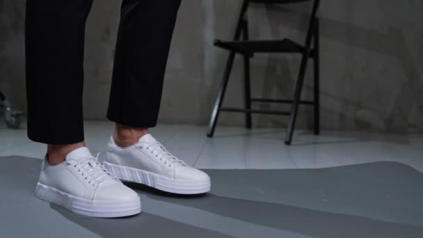 Erkek Ayağında Beyaz Spor Ayakkabılar Kapatın Siyah Pantolon Giyen Adam — Stok video