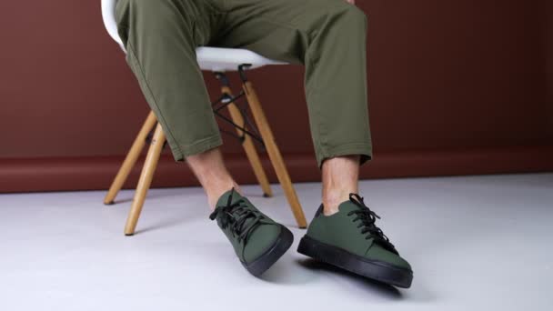 Hombre Usa Pantalones Vaqueros Caqui Zapatillas Caqui Modelo Sienta Silla — Vídeo de stock