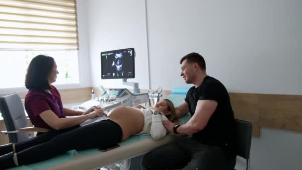 一对夫妇在产科医生的办公室 对未来婴儿进行超声波检查的孕妇 — 图库视频影像
