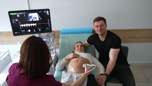 Ehemann Unterstützt Schwangeres Kind Bei Ärztlicher Untersuchung Arzt Führt Ultraschalluntersuchung — Stockvideo