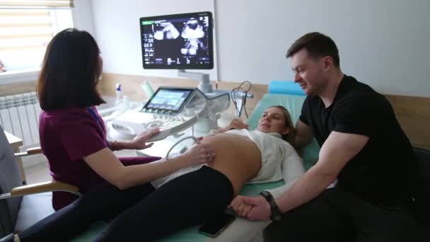 Junges Familienpaar Beim Ultraschall Check Arzt Bewegt Den Sensor Bauch — Stockvideo