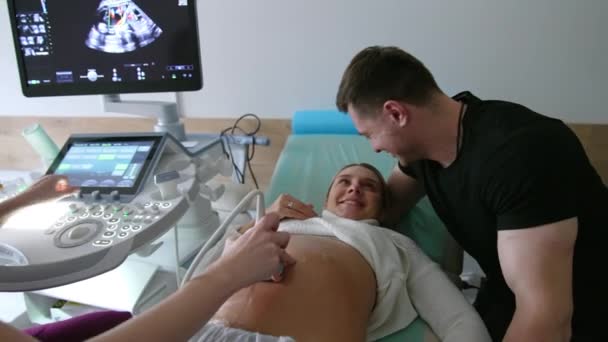 Zufriedene Werdende Eltern Bei Der Ultraschalluntersuchung Ehemann Unterstützt Seine Frau — Stockvideo