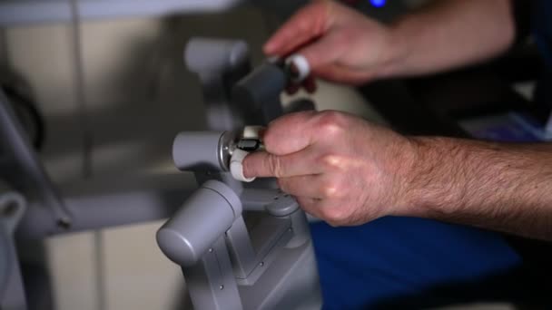 男性外科医生的手操作机器人的手臂 医疗人员移动缓慢 操纵技术设备 靠近点 — 图库视频影像