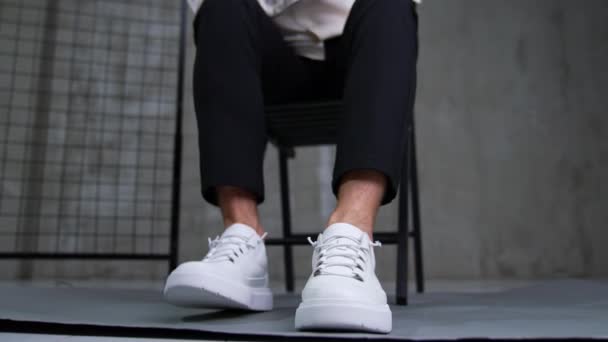 Muž Černých Kalhotách Bílé Košili Dává Tenisky Model Sedí Židli — Stock video