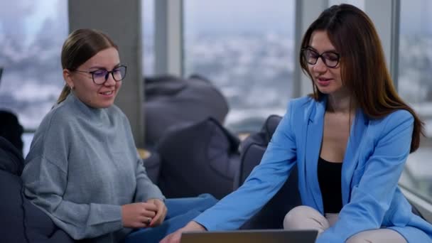 現代のオフィスで働く女性は いくつかの仕事の問題について話し合います 女性はラップトップを見て 彼らが見るものにコメントする — ストック動画
