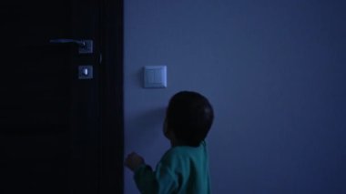 Küçük oğlan karanlık odada ışık düğmesine doğru geliyor. Güzel çocuk ışığı açar ve mutlu bir şekilde uzaklaşır..