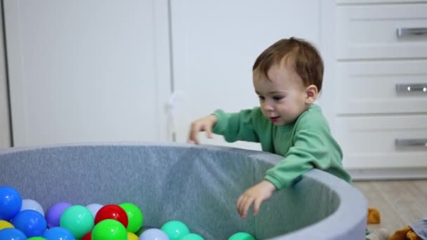 ドライプールでボールで遊ぶハッピーな小さな子供 屋内で楽しい時間を過ごす素敵な幼児 — ストック動画