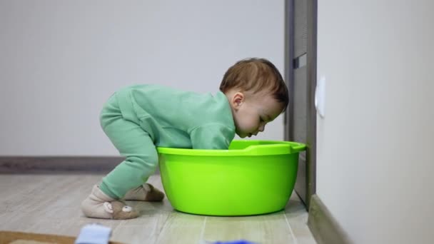 小可爱的幼儿把他的手伸进了洗碗里 婴儿试图进入浴缸 — 图库视频影像