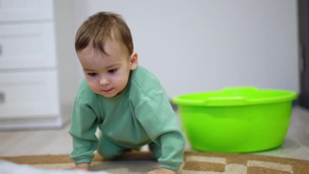漂亮的一岁男孩玩着洗碗 小孩从浴缸里爬进爬出 — 图库视频影像