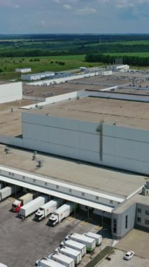 Açık havada üretim kompleksi. Kırsal kesimdeki modern fabrikanın dışında. Yeşil alanlar arasında büyük bir sanayi bölgesi. Hava görüntüsü. Dikey video