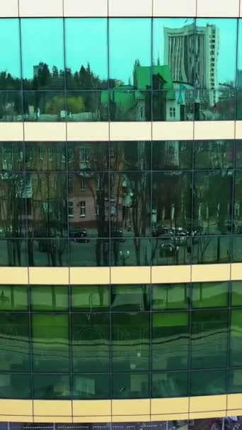 現代建築の鏡の窓のシティスケープの反射 外の街を映したオフィスビルの窓の空中撮影 カメラが正しく動いている バーティカルビデオ — ストック動画