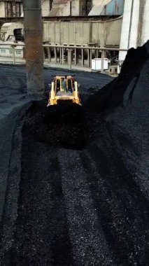 Sürüngen buldozer kömür madenlerinde çalışır. Çıkarma endüstrisi, antrasit. Hava görüntüsü. Dikey video
