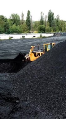 Büyük kömür yığınının havadan görünüşü. Çıkarma endüstrisi, antrasit. Dikey video