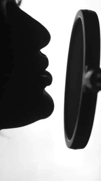 专业歌手在麦克风前 在演播室里表演一首歌 迷人的女性脸谱图唱歌 黑白视频垂直视频 — 图库视频影像