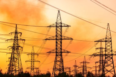 Yüksek voltajlı elektrik hatları ve batan güneş pilonları.