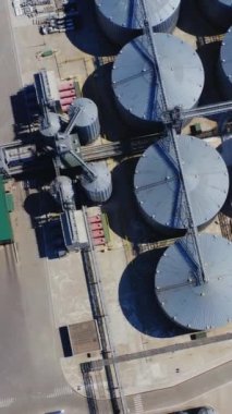 Tahıl asansörü. Sahadaki tarım ürünleri için çelik konteynırların en üst görüntüsü. Depo tahıl ambarı alüminyum kapları. Kamera yavaşça yükseliyor. Dikey video