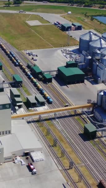 当代工业领域在农村 存放谷物的银质容器的外面 工业园区的火车货运货车 空中风景 垂直录像 — 图库视频影像