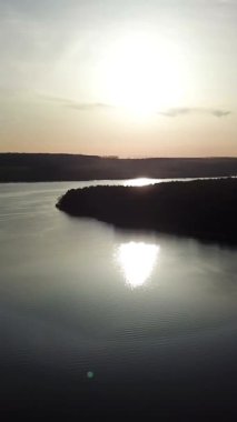 Nehrin muhteşem manzarası. Güneşin yansıması havadan görünüyor. Kamera arkası hareket. Gün doğumu. Dikey video