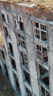 Eski terk edilmiş bir fabrikanın çatısı harabeye dönmüş. Yıkım için sanayi binası. Hava görüntüsü. Dikey video
