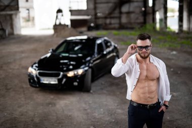 Güçlü gövdeli, ayakta duran seksi maço adam. Yakışıklı kaslı model çocuk..