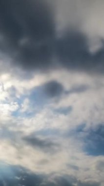 Atmosferde biriken koyu gri bulutlar. Kümülüs bulutları gökyüzünü kaplıyor. Zaman ayarlı. Dikey video
